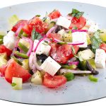 A greek salad on a white plate